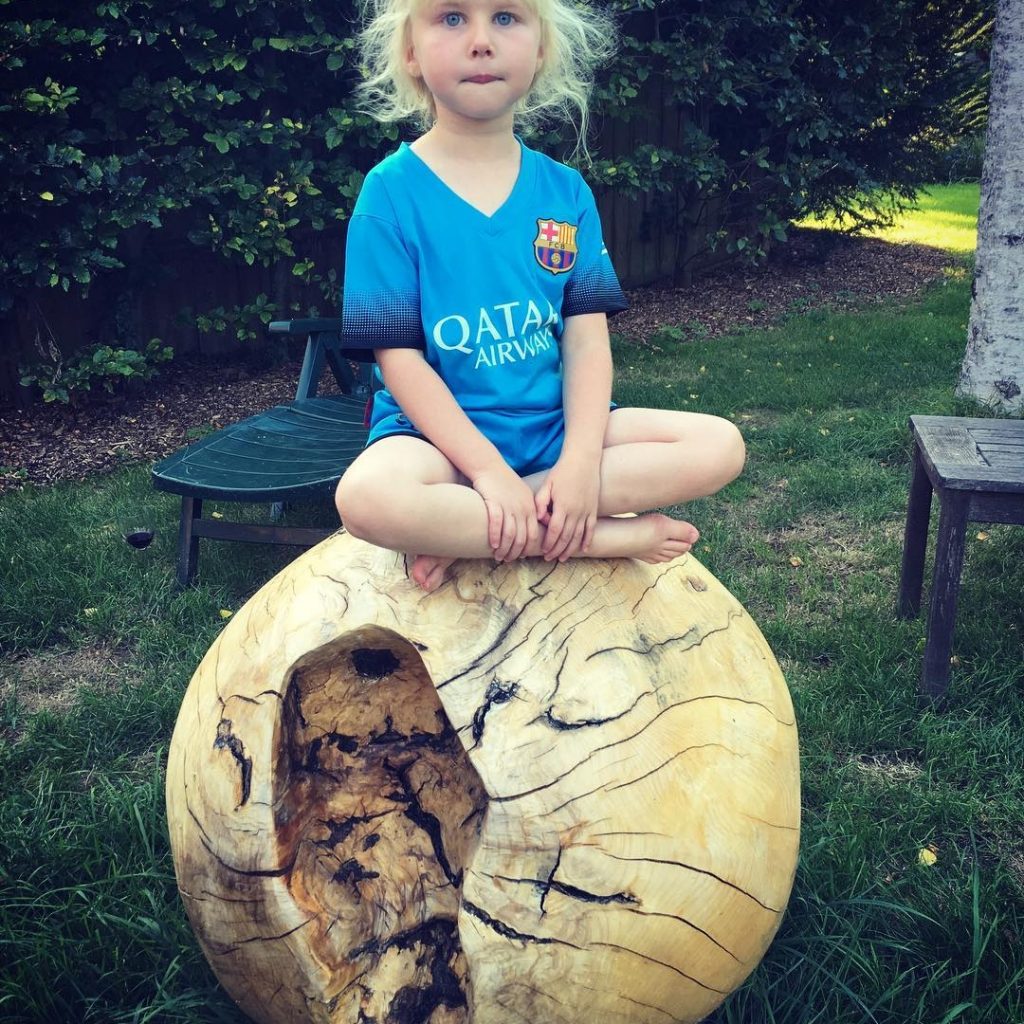 My little girl having fun on one of my garden spheres #sculpture #woodsculpture